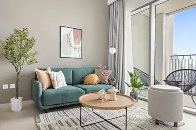a living room with a green couch and a table at Silkhaus Ultra Luxury 1BDR in New Tower of Downtown in Dubai