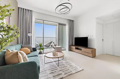 a living room with a blue couch and a tv at Silkhaus Ultra Luxury 1BDR in New Tower of Downtown in Dubai