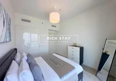 a white bedroom with a large bed and a chandelier at Incredible 1BR, Downtown Views II near Dubai Mall in Dubai