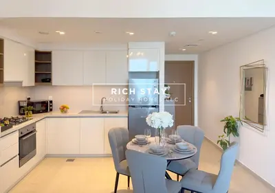 a kitchen and dining room with a table and chairs at Incredible 1BR, Downtown Views II near Dubai Mall in Dubai