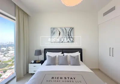a white bedroom with a large bed and a window at Incredible 1BR, Downtown Views II near Dubai Mall in Dubai