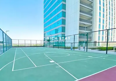 a tennis court in front of a tall building at Incredible 1BR, Downtown Views II near Dubai Mall in Dubai