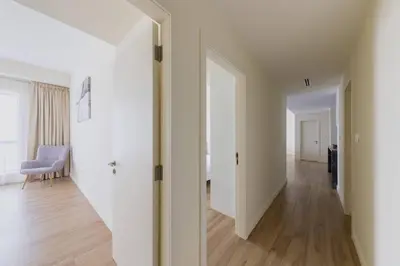 an empty hallway with white walls and wood floors at Luxury Living on the Top Floor Full Marina View in Dubai