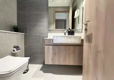 a bathroom with a sink and a toilet and a mirror at Exceptional 1 BR in Prive Residences Dubai Hills in Dubai