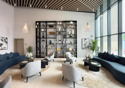 a living room with a blue couch and chairs at Exceptional 1 BR in Prive Residences Dubai Hills in Dubai