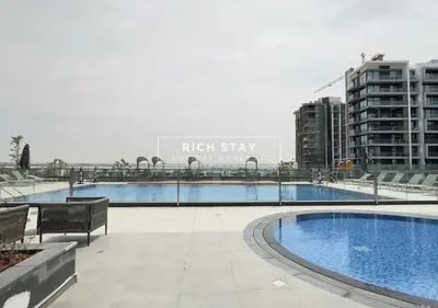 a large swimming pool in a city with buildings at Exceptional 1 BR in Prive Residences Dubai Hills in Dubai