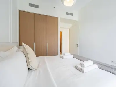 a bedroom with a large white bed with two pillows at Dubai Creek Escape: Luxury 3BR Nautical Grandeur in Dubai