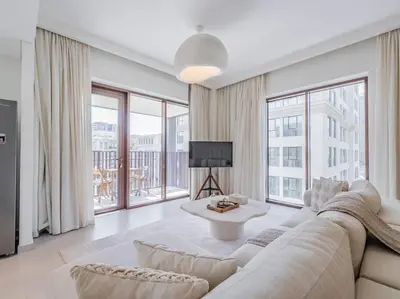 a white living room with a couch and a tv at Dubai Creek Escape: Luxury 3BR Nautical Grandeur in Dubai