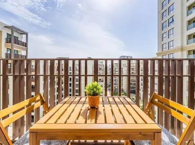 a wooden table with a potted plant on a balcony at Dubai Creek Escape: Luxury 3BR Nautical Grandeur in Dubai