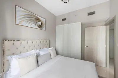 a bedroom with a white bed and a picture on the wall at ALiving Classy 1BR I Close to Dubai Mall I Zada Tower, Business Bay- 1617 in Dubai