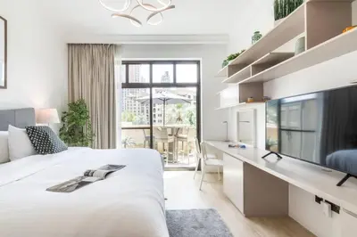 a white bedroom with a large bed and a desk at FIRST CLASS 1BR Tranquil Oasis in Old Town in Dubai