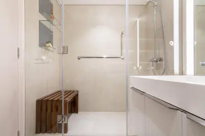 a shower with a glass door next to a sink at FIRST CLASS 1BR Tranquil Oasis in Old Town in Dubai