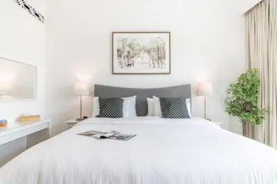 a bedroom with a white bed with a magazine on it at FIRST CLASS 1BR Tranquil Oasis in Old Town in Dubai