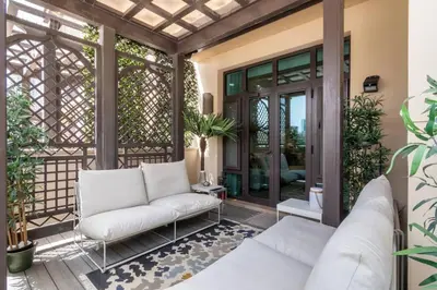 a screened in porch with a white couch at FIRST CLASS 1BR Tranquil Oasis in Old Town in Dubai