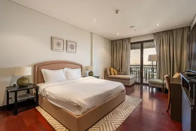 a hotel room with a bed and a balcony at Anantara South Residences I Stunning 1 Bedroom Apartment in Dubai