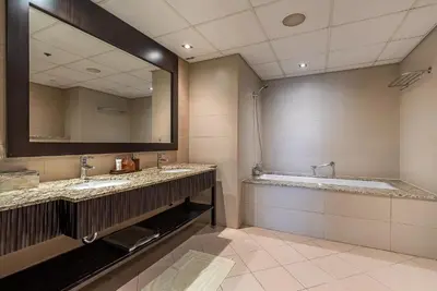 a bathroom with two sinks and a large mirror at Anantara South Residences I Stunning 1 Bedroom Apartment in Dubai