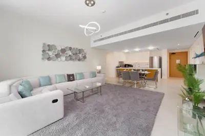 a living room with a white couch and a table at Maison Privee - Seaside JBR Living w/ Open Sea & Bluewaters Views in Dubai