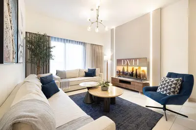 a living room with a white couch and blue chairs at Burj Crown - First Class Boulevard View, 9 min Walk Dubai Mall in Dubai
