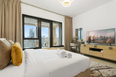 a bedroom with a white bed and a large window at Luxury Studio, 29 Boulevard near Burj Khalifa Downtown - Chalet Homes in Dubai