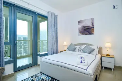 a white bedroom with a bed and a balcony at Luxury Escapes - Modern Studio Apt with Balcony near Dubai Mall - 29 Blvd in Dubai