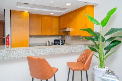a kitchen with orange chairs and a counter with a plant at Escape24 Spacious Studio with Balcony near Dubai Mall in Dubai