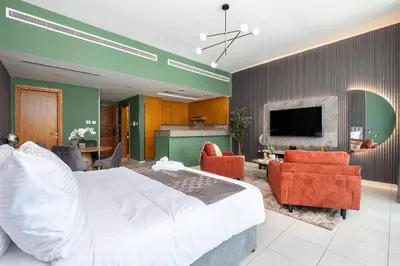 a bedroom with a large bed and a living room at Escape24 Spacious Studio with Balcony near Dubai Mall in Dubai