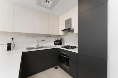 a kitchen with black and white cabinets and a sink at Luxury Living resort style in Zaya Hameni in Dubai
