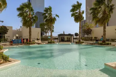 a large swimming pool with palm trees in a building at Luxury Living resort style in Zaya Hameni in Dubai