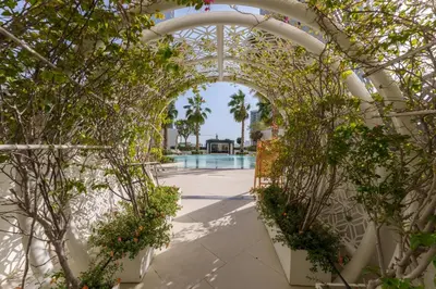 an archway with plants and a pool in the background at Luxury Living resort style in Zaya Hameni in Dubai