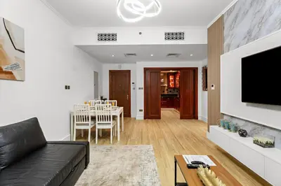 a living room with a black couch and a dining room at Stylish 1BR in Old Dubai Balcony, Smart TV, Full Kitchen in Dubai
