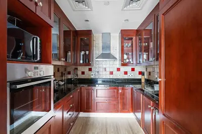 a large kitchen with wooden cabinets and appliances at Stylish 1BR in Old Dubai Balcony, Smart TV, Full Kitchen in Dubai