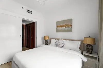 a white bedroom with a white bed and two lamps at Stylish 1BR in Old Dubai Balcony, Smart TV, Full Kitchen in Dubai