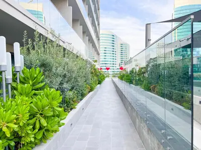 a walkway in the middle of a building with plants at MAG318, Modern Studio Apartment with Great Amenities and Canal View, 5min Walk to Dubai Mall in Dubai