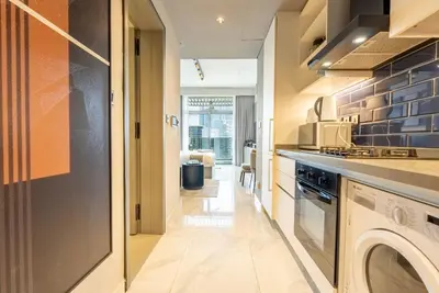 a kitchen with a washer and dryer in a room at MAG318, Modern Studio Apartment with Great Amenities and Canal View, 5min Walk to Dubai Mall in Dubai