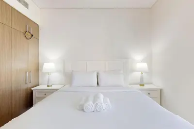 a bedroom with a white bed with two towels at 5242 Tower 2 - Cosy One Bedroom in Dubai