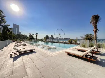a swimming pool with chaise lounges and a ferris at Fantastic and Rare 4BR+maid's in JBR Walk in Dubai