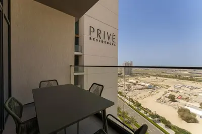 a balcony with a table and chairs in front of a building at Your Exclusive Retreat in Dubai Hills by Suiteable in Dubai