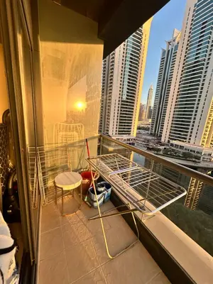 a room with a balcony with a bed and chairs at Click Stay - JLT - Studio & Balcony Lakes view Entire Apartment -RA in Dubai