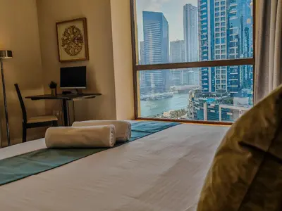 a bedroom with a large window with a view of a city at Modern, spacious, Luxe 5BR plus Maid condo in JBR, near JBR Beach, Marina view, By La Buena Vida Holiday Homes in Dubai