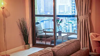 a living room with a couch and a glass window at Modern, spacious, Luxe 5BR plus Maid condo in JBR, near JBR Beach, Marina view, By La Buena Vida Holiday Homes in Dubai