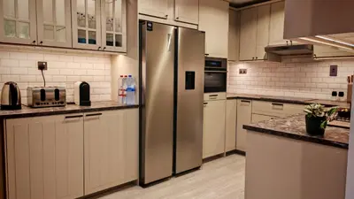 a large kitchen with a stainless steel refrigerator at Modern, spacious, Luxe 5BR plus Maid condo in JBR, near JBR Beach, Marina view, By La Buena Vida Holiday Homes in Dubai