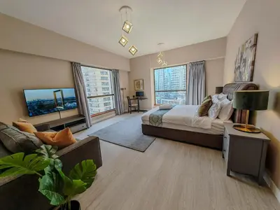 a large bedroom with a bed and a couch at Modern, spacious, Luxe 5BR plus Maid condo in JBR, near JBR Beach, Marina view, By La Buena Vida Holiday Homes in Dubai