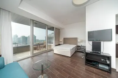 a bedroom with a bed and a flat screen tv at StoneTree - Spacious Studio - The Matrix in Dubai