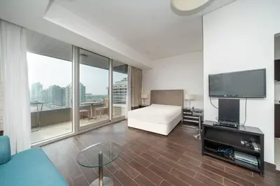 a hotel room with a bed and a television at StoneTree - Spacious Studio - The Matrix in Dubai