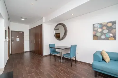 a dining room with a table and chairs and a couch at StoneTree - Spacious Studio - The Matrix in Dubai