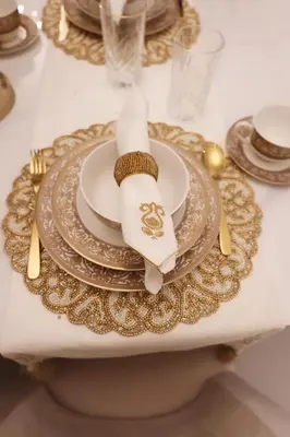 a table with plates and gold chargers on it at 2BR apartment in downtown Dubai, near Burj Khalifa in Dubai