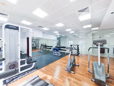 a gym with treadmills and ellipticals in a room at Comfortable 1BR Apartment in Marina Tower, Dubai Marina by Deluxe Holiday Homes in Dubai