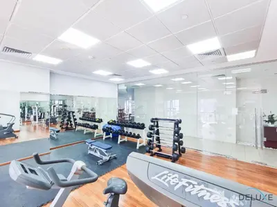 a gym with treadmills and machines in a room at Comfortable 1BR Apartment in Marina Tower, Dubai Marina by Deluxe Holiday Homes in Dubai