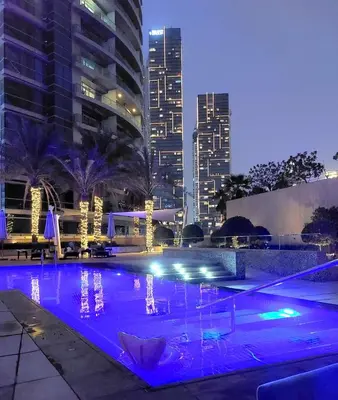 a swimming pool in a city at night at Comfortable 1BR Apartment in Marina Tower, Dubai Marina by Deluxe Holiday Homes in Dubai