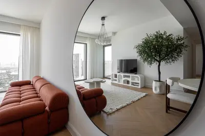 a living room with a couch and a table and a mirror at TH-Homes designed apartment Downtownview in Dubai